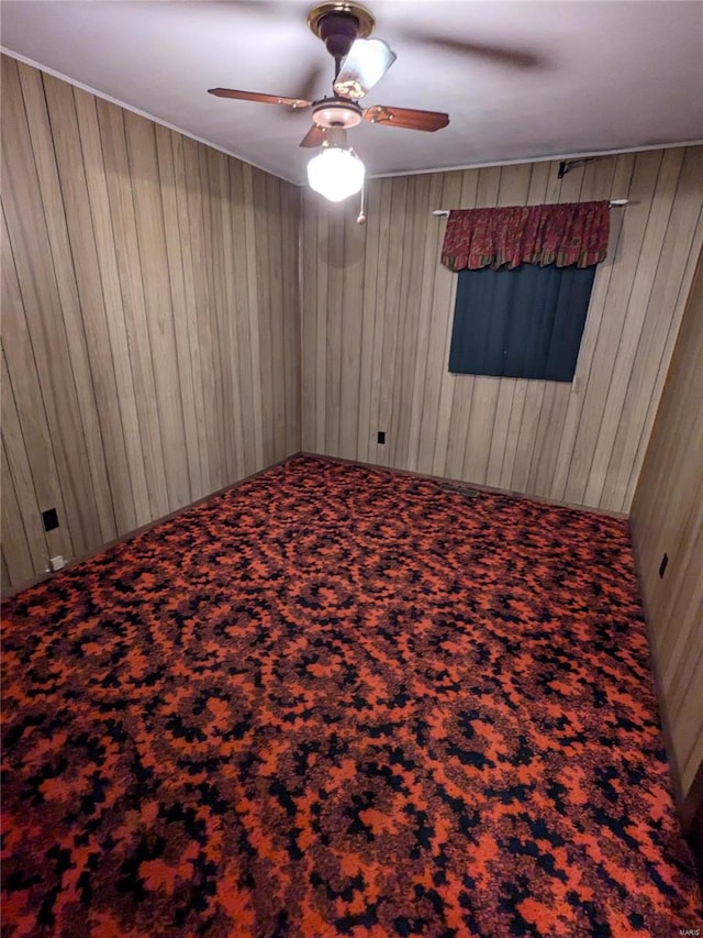 unfurnished bedroom with wood walls and ceiling fan