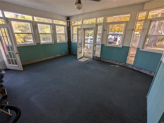 unfurnished sunroom featuring ceiling fan