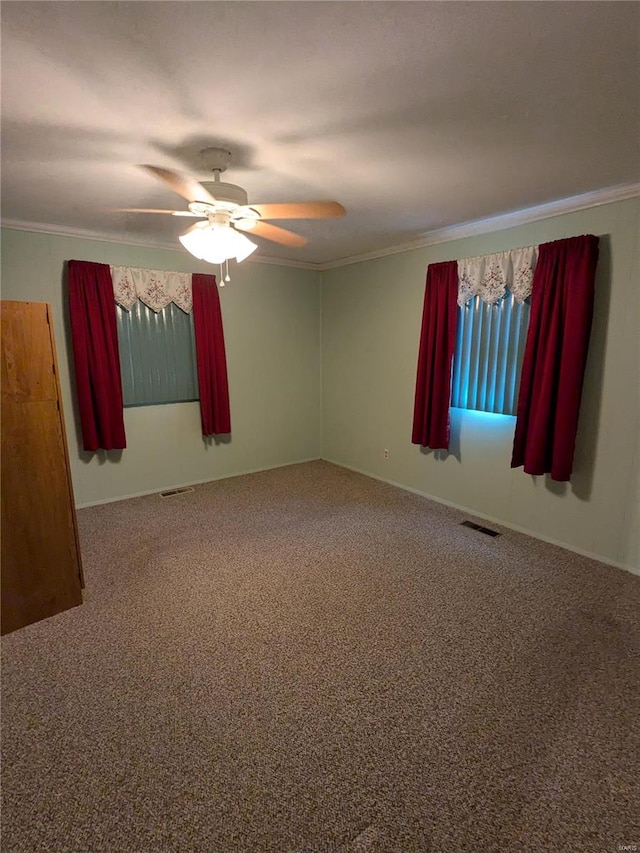 spare room with ornamental molding, a healthy amount of sunlight, carpet floors, and ceiling fan