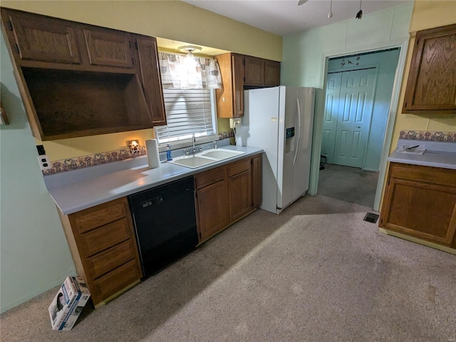 kitchen with white refrigerator with ice dispenser, light colored carpet, sink, and black dishwasher