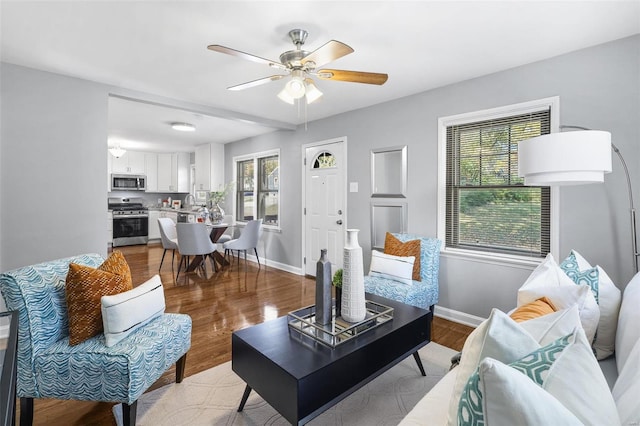 living room featuring light hardwood / wood-style floors, a healthy amount of sunlight, and ceiling fan