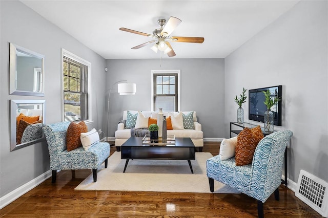 living room featuring ceiling fan and dark hardwood / wood-style flooring