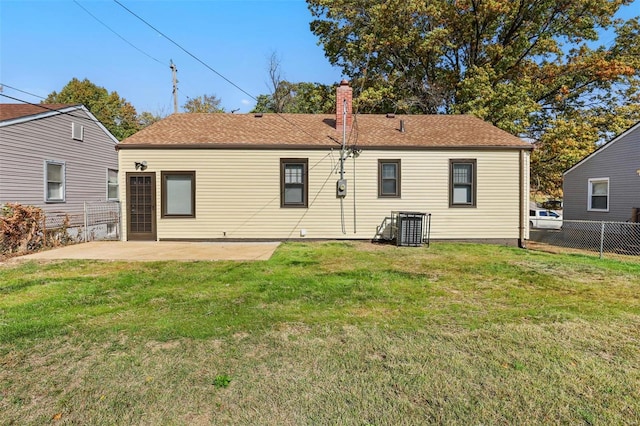 rear view of house with a patio and a lawn