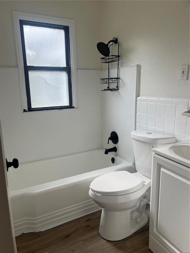 full bathroom with vanity, toilet, wood-type flooring, and washtub / shower combination