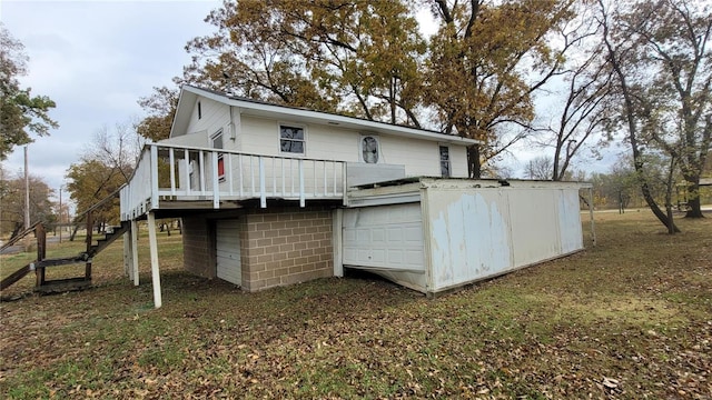 back of house with a garage and a deck