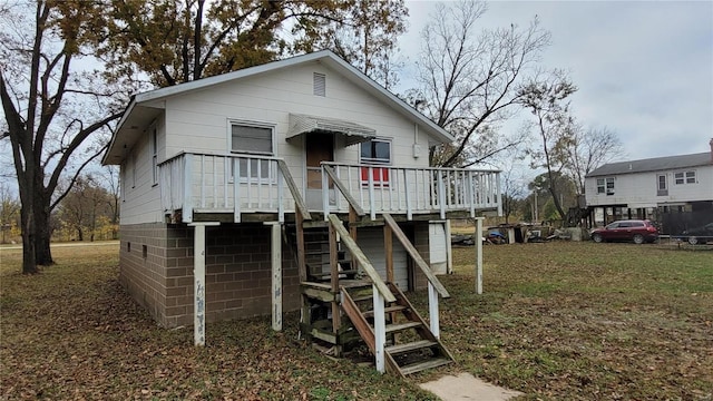 rear view of property with a yard and a deck