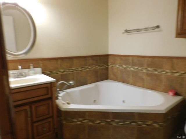 bathroom featuring vanity and tiled bath