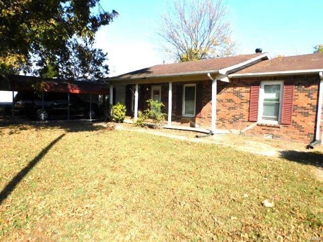 view of front of house with a front lawn and a carport