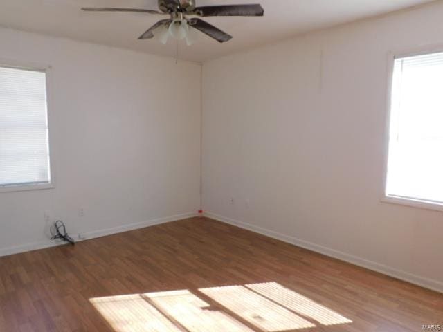 empty room with ceiling fan, wood-type flooring, and a wealth of natural light