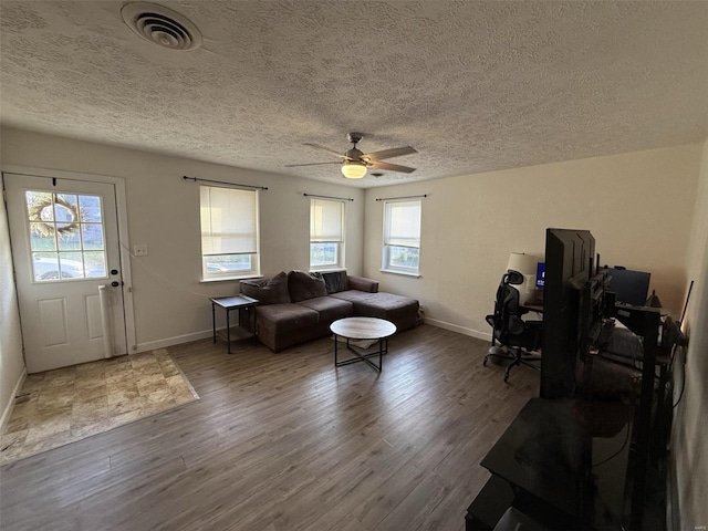 living room with a wealth of natural light, a textured ceiling, hardwood / wood-style flooring, and ceiling fan