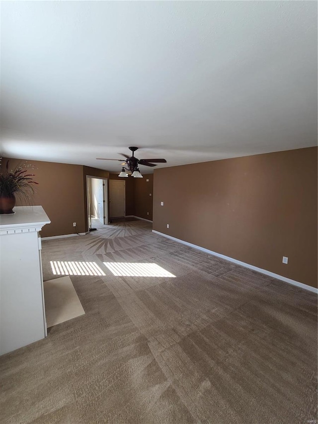 unfurnished living room with ceiling fan and carpet