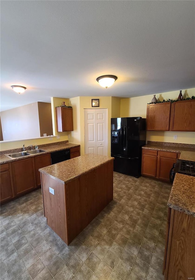 kitchen with black appliances, a kitchen island, and sink