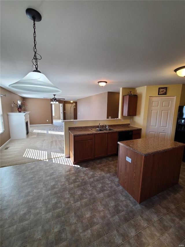 kitchen featuring kitchen peninsula, a wealth of natural light, ceiling fan, sink, and decorative light fixtures