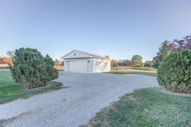 exterior space with a garage, a lawn, and an outdoor structure