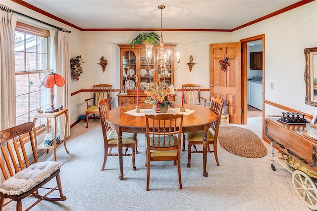 carpeted dining room with ornamental molding and washer / dryer