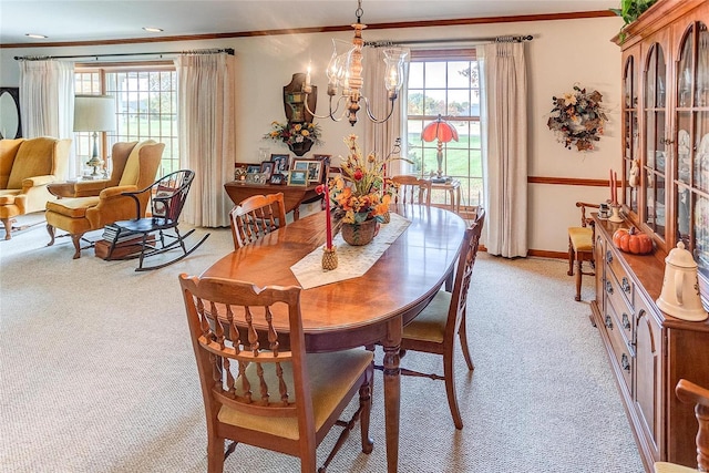 carpeted dining area featuring an inviting chandelier and crown molding