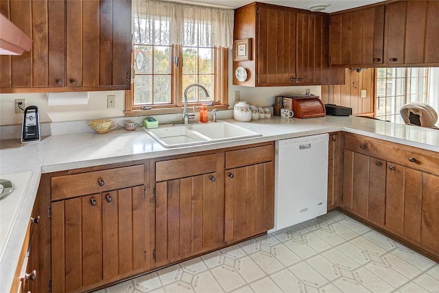 kitchen with sink, white dishwasher, ventilation hood, and light tile patterned flooring