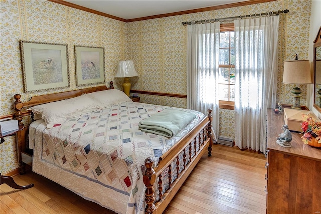 bedroom featuring multiple windows, light hardwood / wood-style flooring, and ornamental molding