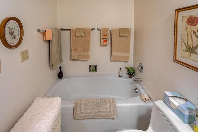 bathroom featuring a washtub and toilet