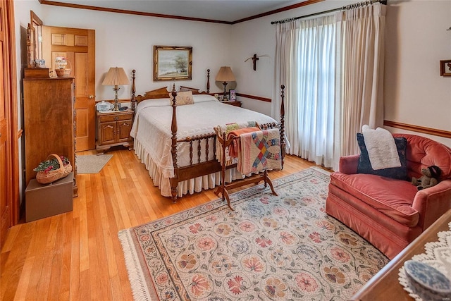 bedroom featuring ornamental molding and light hardwood / wood-style flooring