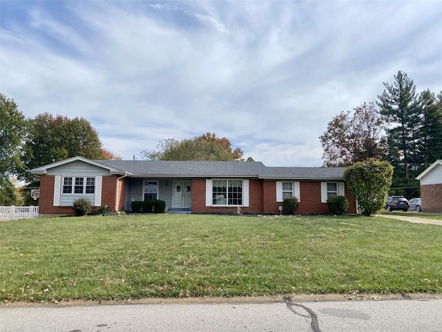 single story home with brick siding, a front yard, and fence