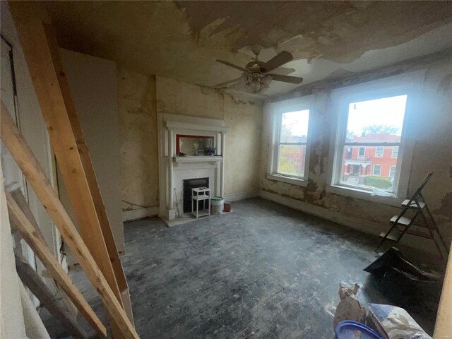 unfurnished living room featuring ceiling fan