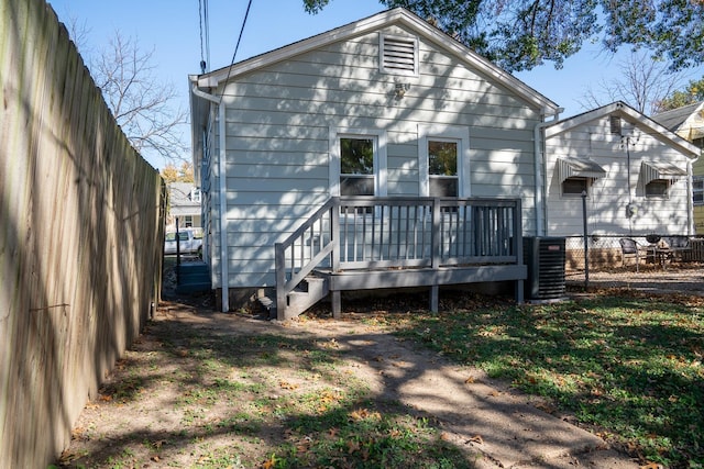 rear view of property with a wooden deck and central AC unit