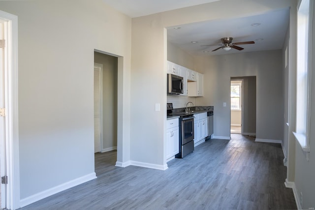 kitchen featuring sink, hardwood / wood-style floors, ceiling fan, stainless steel appliances, and white cabinets