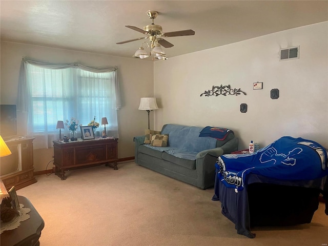 carpeted living room with ceiling fan