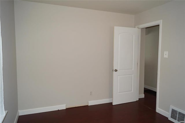 spare room featuring dark wood-type flooring