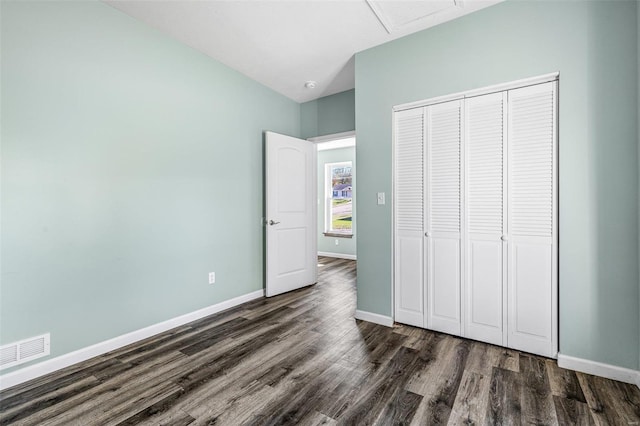 unfurnished bedroom featuring a closet and dark hardwood / wood-style flooring