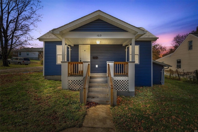 bungalow-style home with a lawn and a porch