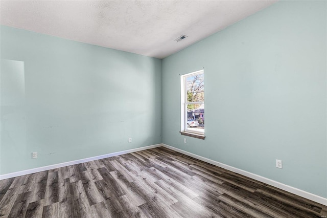 unfurnished room featuring wood-type flooring and a textured ceiling