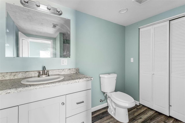 bathroom featuring toilet, vanity, and wood-type flooring