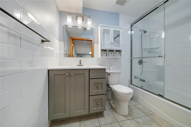 full bathroom with vanity, combined bath / shower with glass door, tile walls, and tile patterned floors