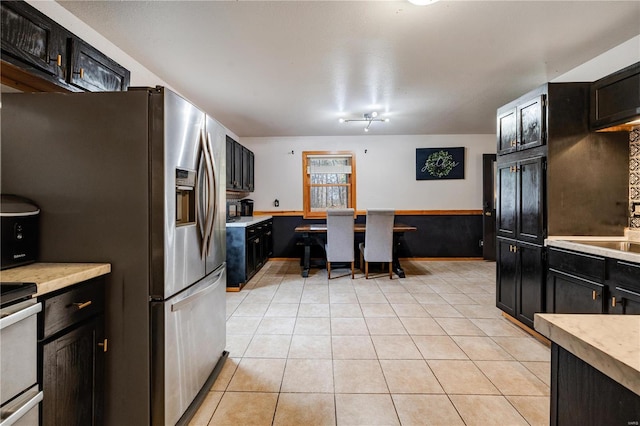 kitchen with light tile patterned floors and stainless steel fridge