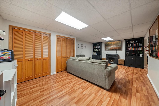 living room featuring a drop ceiling and light hardwood / wood-style floors