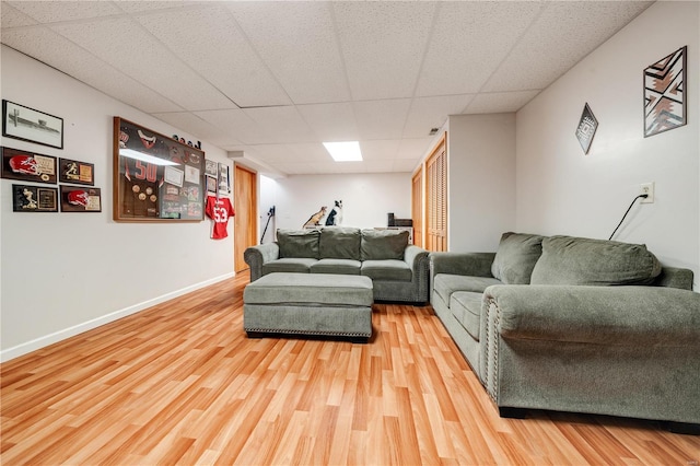 living room with wood-type flooring and a paneled ceiling