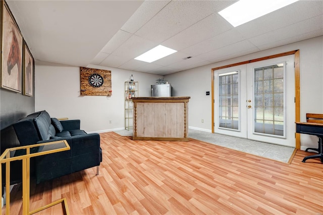 living room with wood-type flooring, french doors, and a drop ceiling