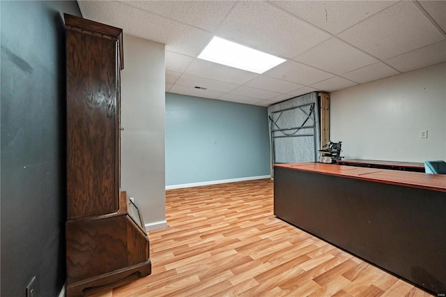 office featuring a paneled ceiling and light hardwood / wood-style floors