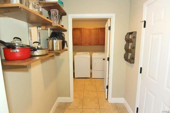 laundry area featuring cabinets, washer and dryer, and light tile patterned floors