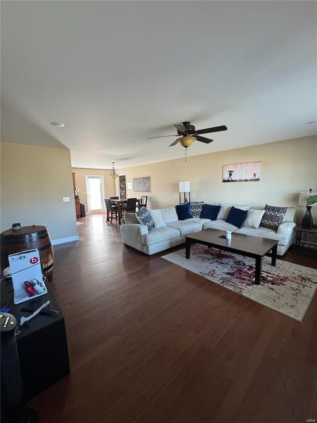 living room featuring dark wood-type flooring and ceiling fan