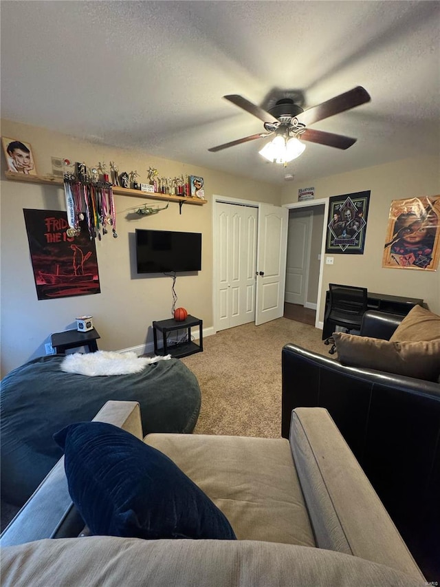 carpeted living room featuring ceiling fan and a textured ceiling