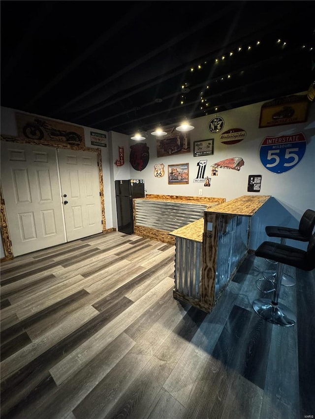 bar featuring butcher block countertops and hardwood / wood-style floors