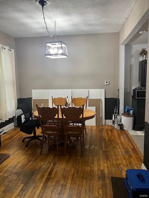 dining area with a textured ceiling and hardwood / wood-style flooring