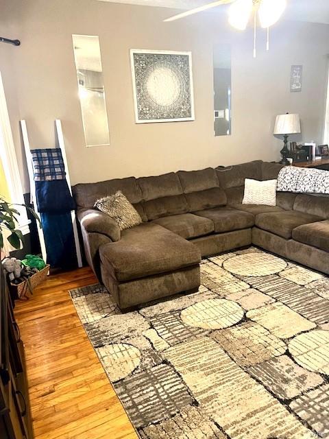 living room featuring wood-type flooring and ceiling fan