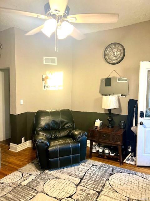 living room featuring wood-type flooring and ceiling fan