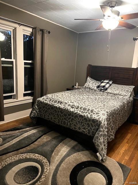 bedroom with dark hardwood / wood-style floors and ceiling fan