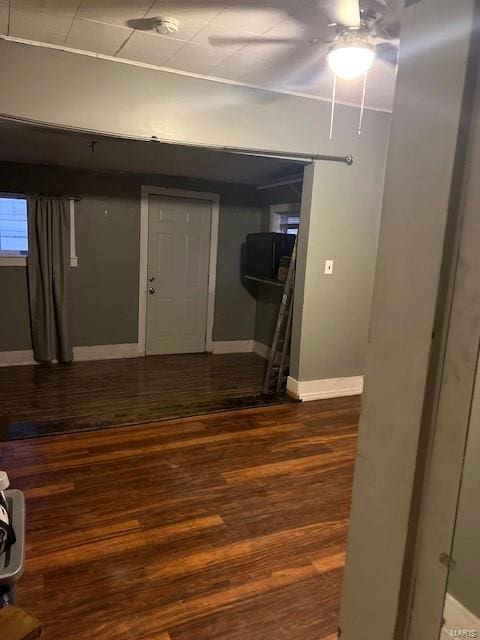 basement featuring dark wood-type flooring and ceiling fan