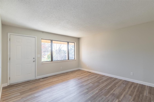 foyer featuring light hardwood / wood-style flooring and a textured ceiling